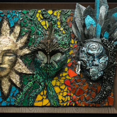 A mosaic artwork with a sun and other masks.
